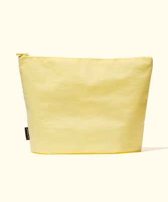 A versatile yellow pouch for customizing your essentials, perfect for your on-the-go lifestyle; Build Your Own Bag by Sun Bum.