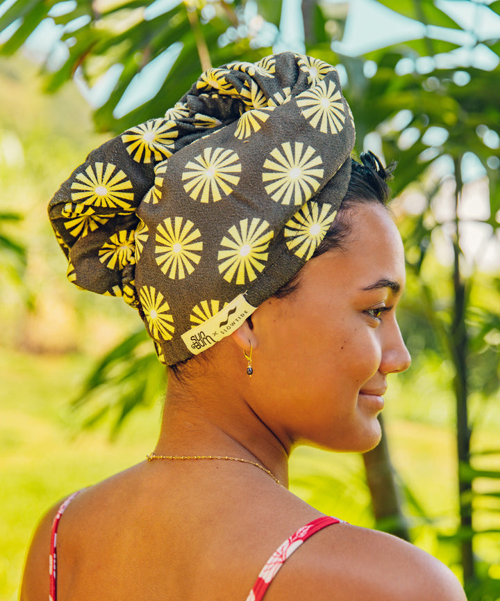 Woman wearing SB x Slowtide Limited Edition Hair Towel with a floral pattern, protecting her hair against frizz, breakage, and dullness. Sun Bum