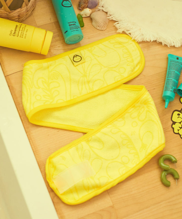 Yellow super soft skin care headband designed to keep hair back during face washing and skin care routine, Sun Bum.